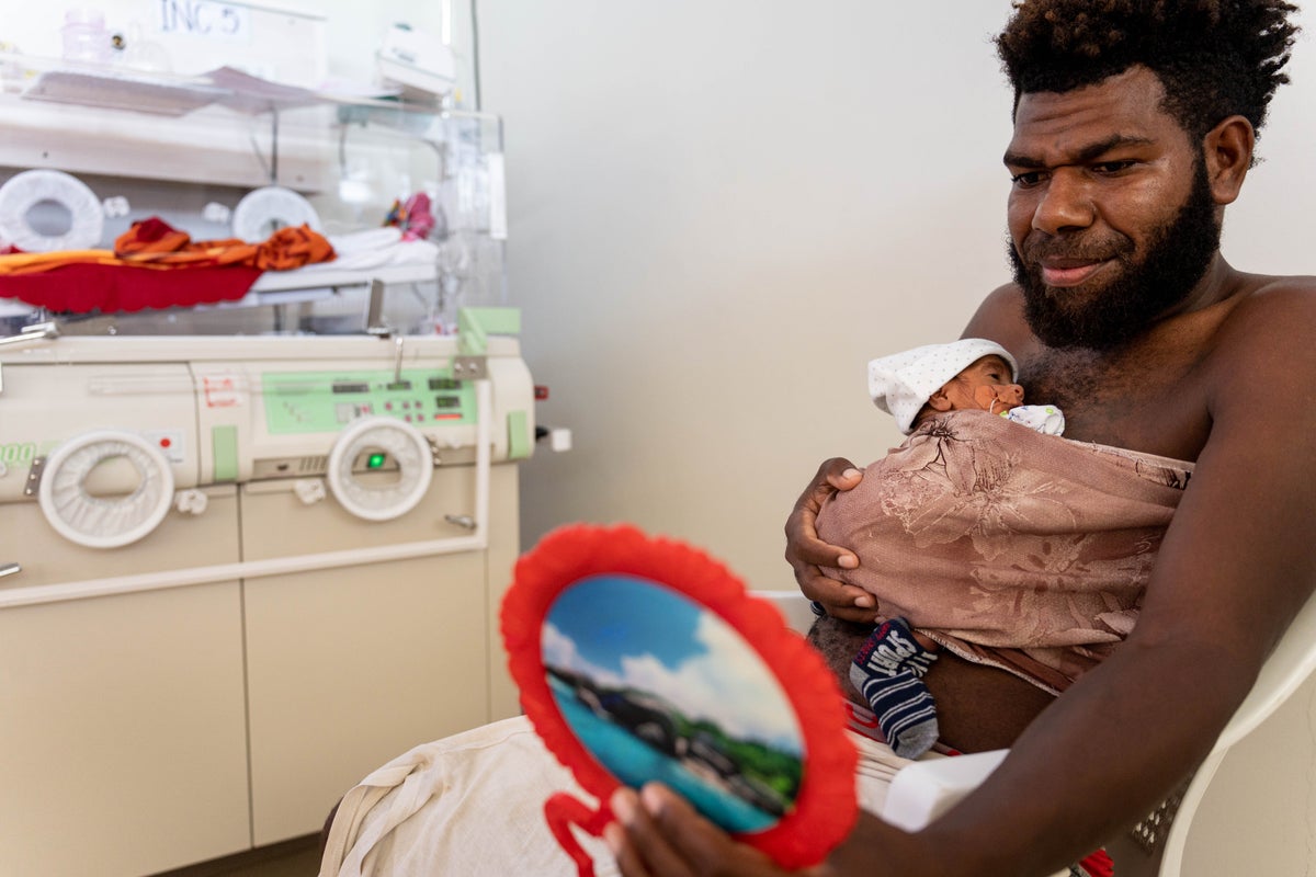In Vanuatu, Tony holds his one-week-old twin daughter.