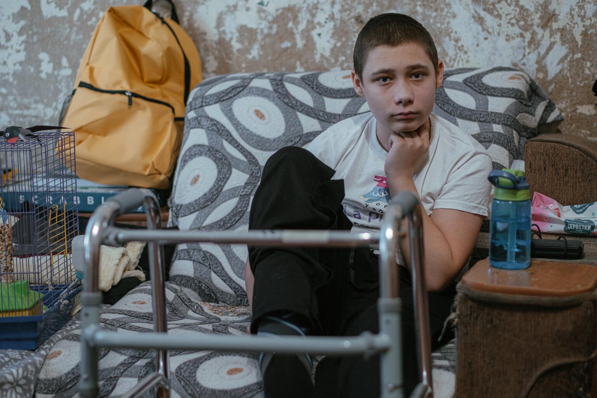 In Ukraine, 10-year-old Andrii hugs his mum inside their home.  