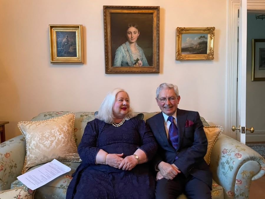 A woman and a man sit on a couch