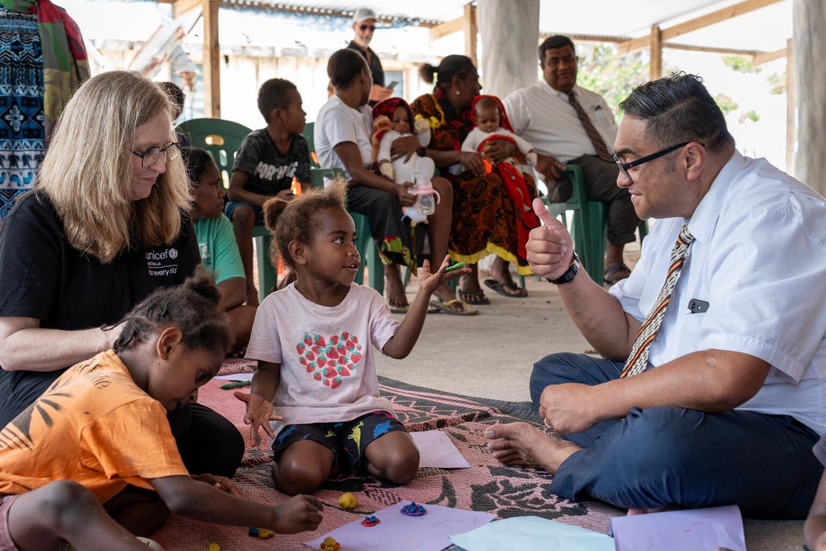 Two young children interacting with adults at a learning centre