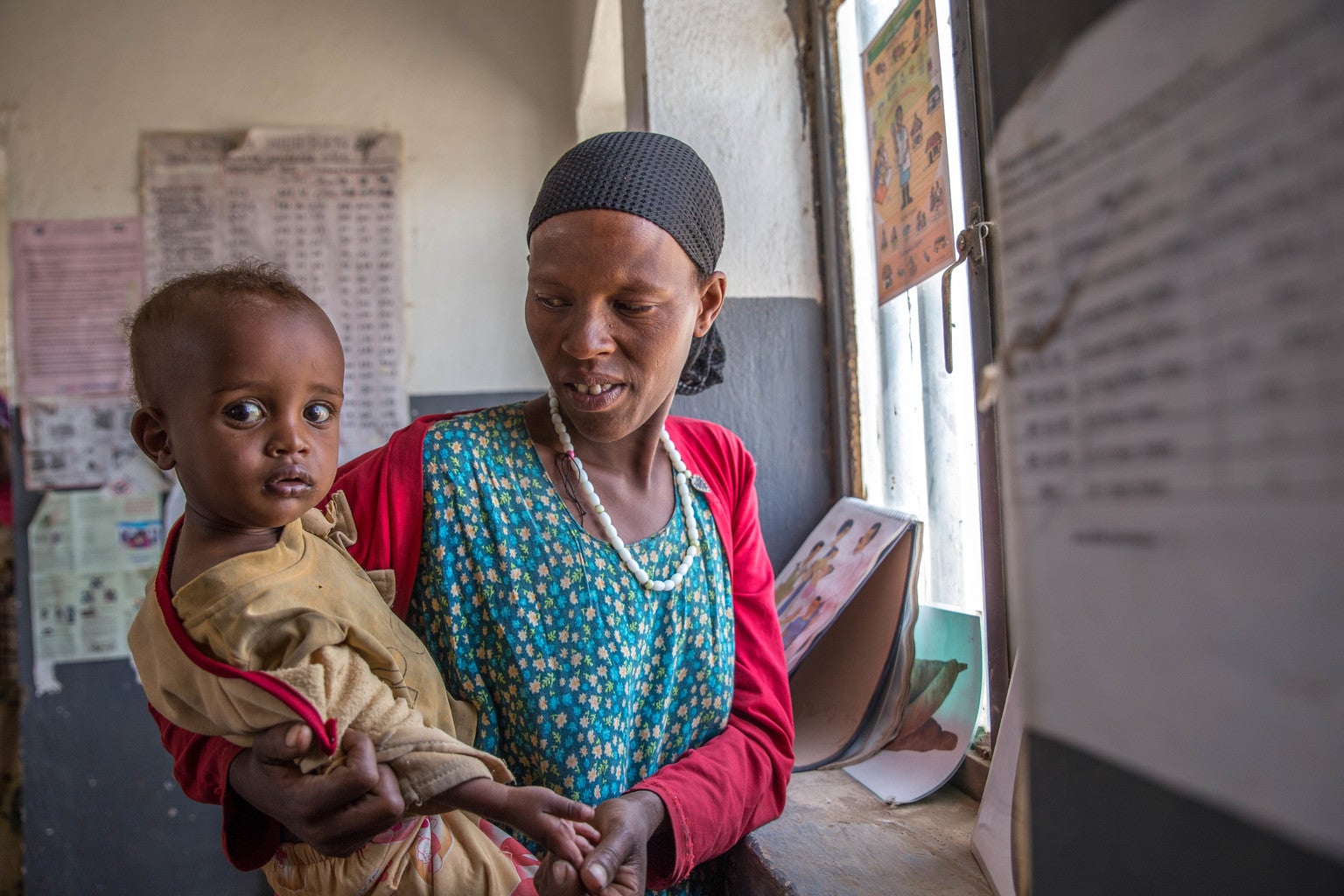 A woman holds a toddler in her arms