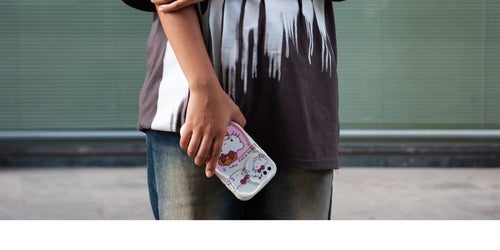 A young girl whose face isn't shown to protect her identity holds her phone. 