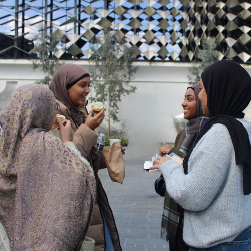 A Ukrainian girl standing outside a destroyed apartment building