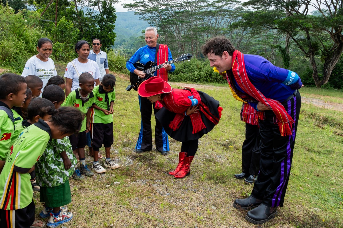 A musical group bowing to a group of kids.