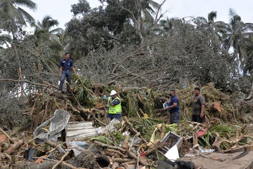 A group of people is working to move debris from the tsunami