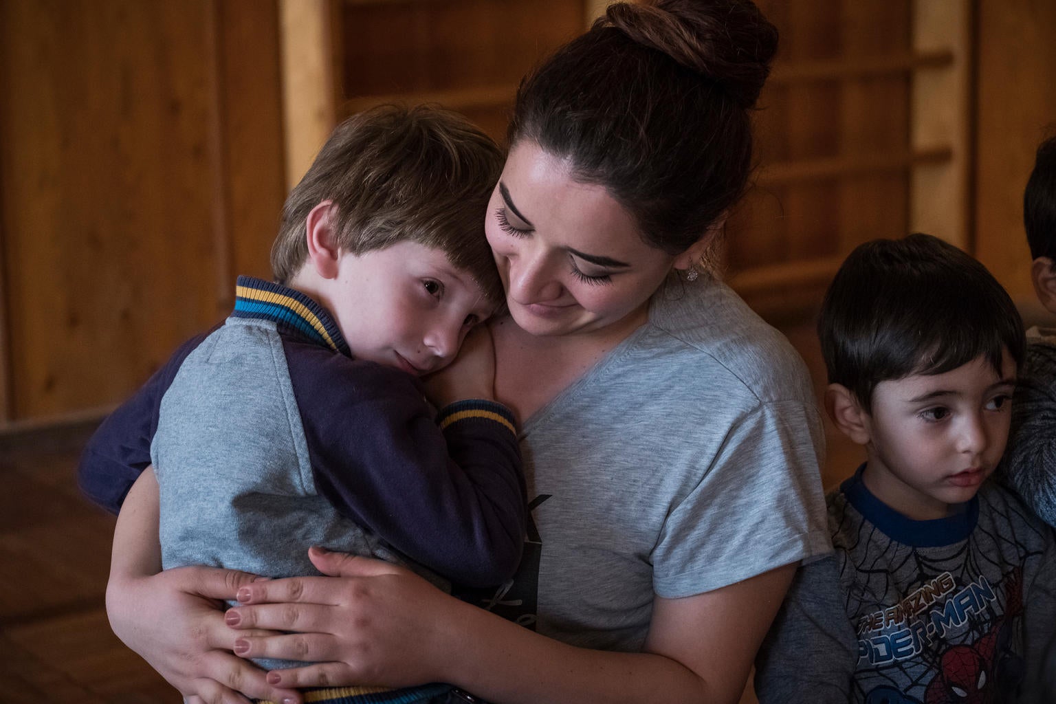 In 2018 in Armenia, a boy hugs his therapist during a music class for children with disabilities