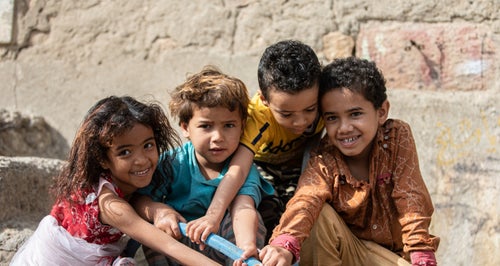 Smiling kids playing with water from well