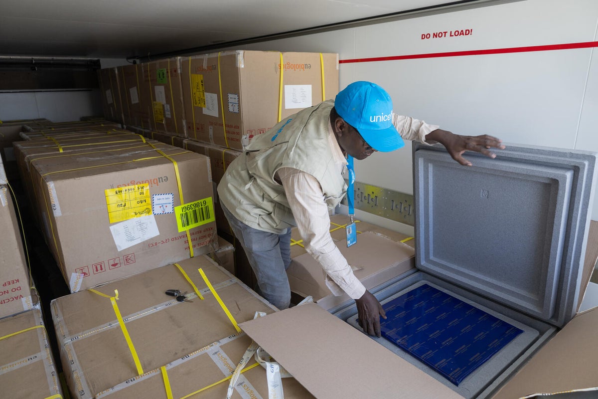 A UNICEF Health Officer inspects a shipment of cholera vaccines in the back of a refrigerated truck. 
