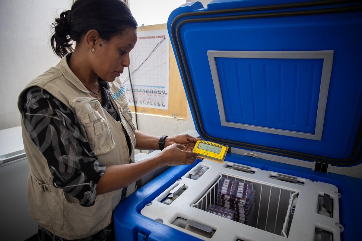 A UNICEF Health Specialist in Ethiopia checks the temperature of the cold-storage fridge.