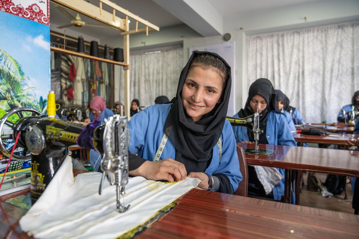 A woman learns sewing to support her family.