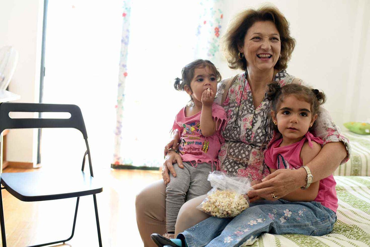 Eugenia sits with two of the Syrian refugee children she is helping. 