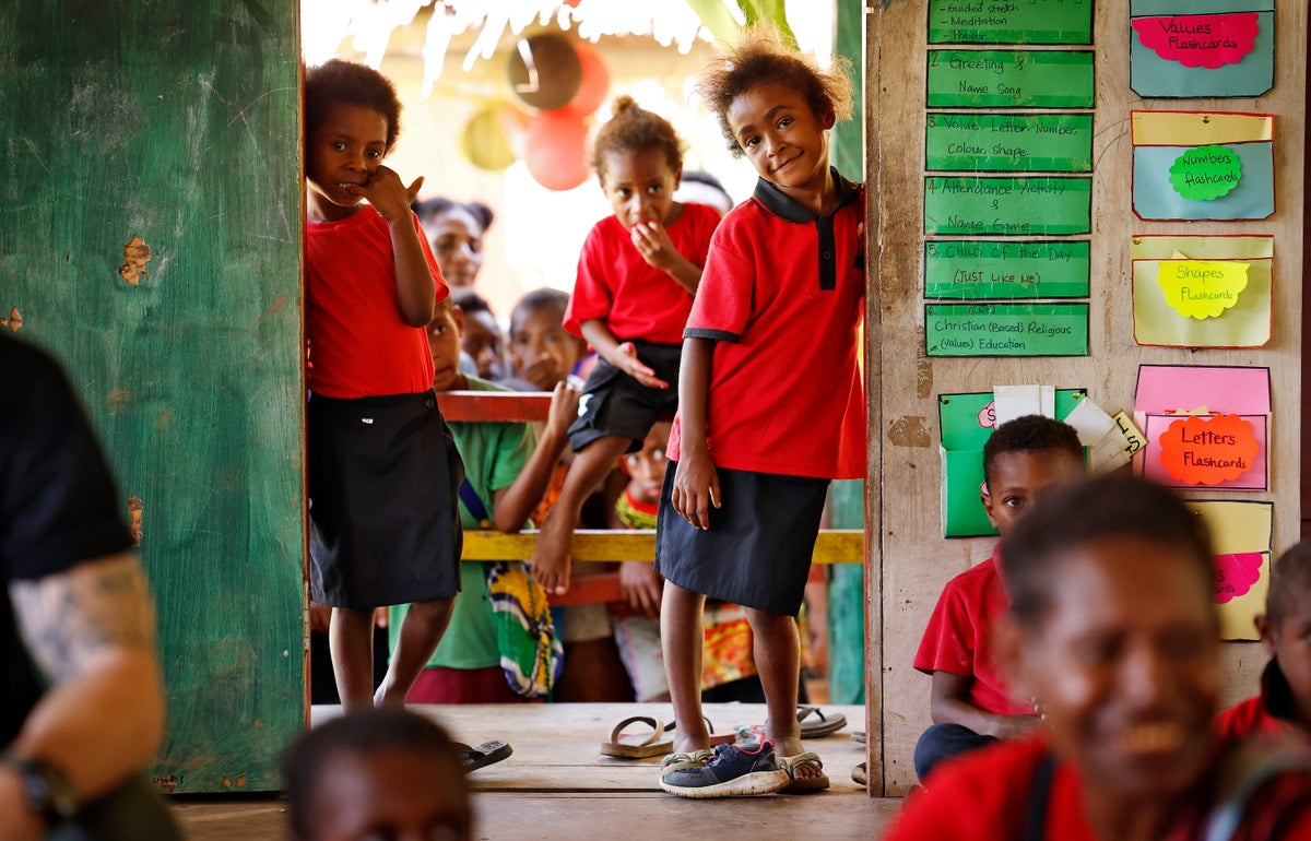 Children watch on as the UNICEF team arrives at the early childhood education centre.