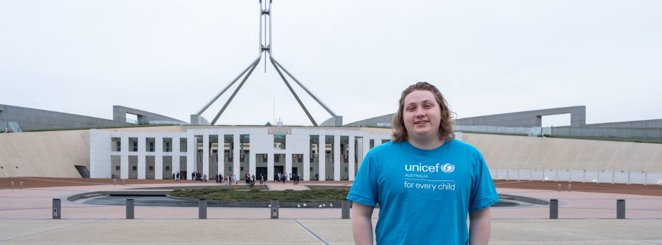 UNICEF Australia Young Ambassador Reede stands in front of Parliament House in Canberra.