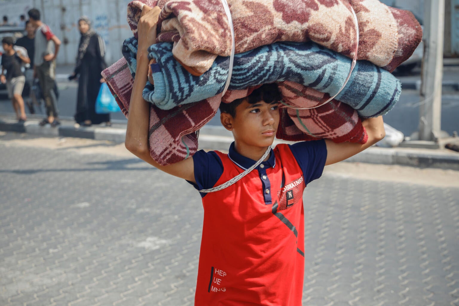 Girl standing outside temporary shelter in the Gaza Strip conflict.