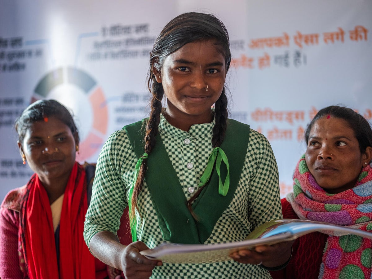 A young girl holding a book. 