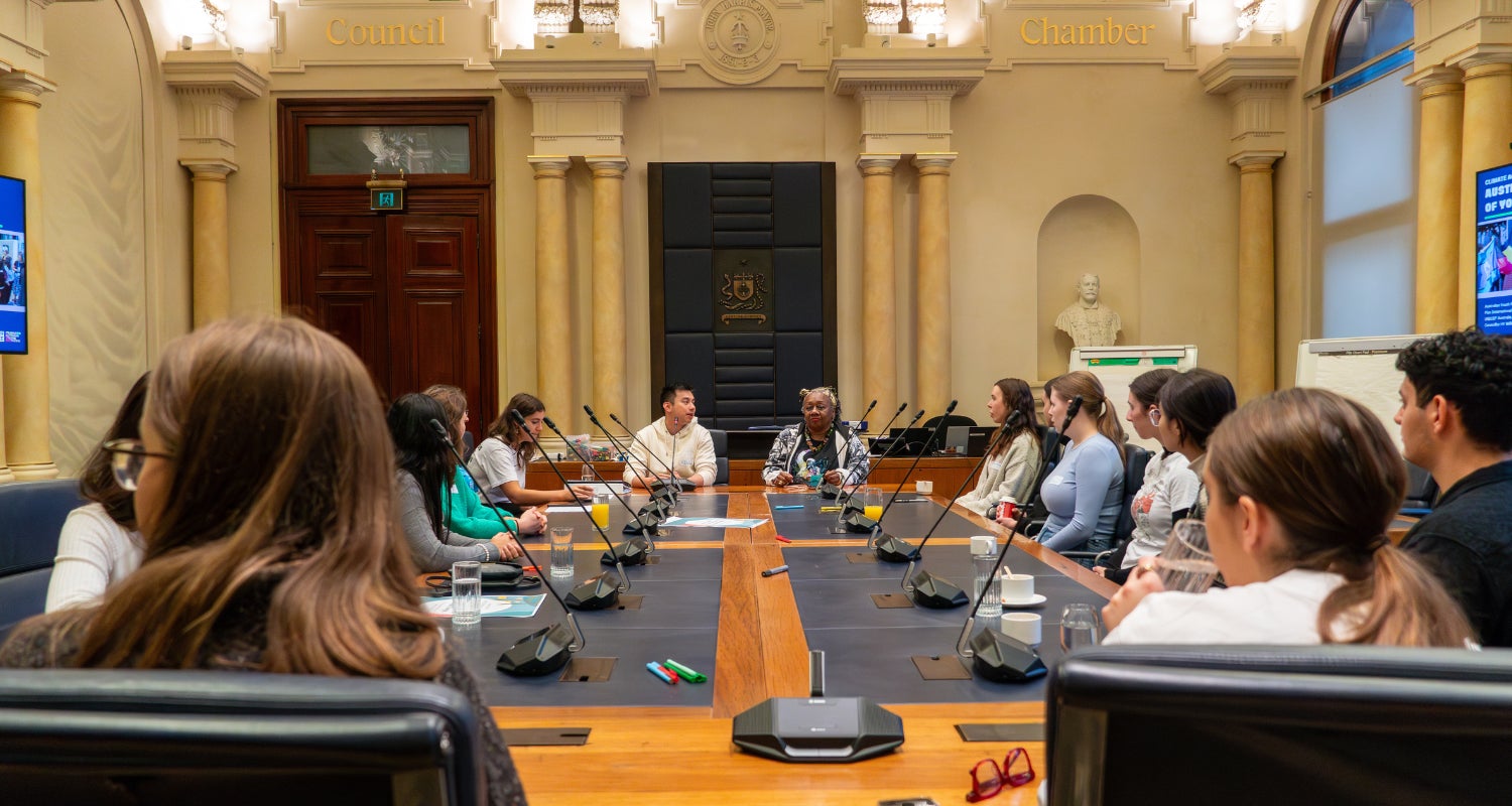 A group of young people engage in a group discussion at the Council Chambers in Sydney Town Hall. 