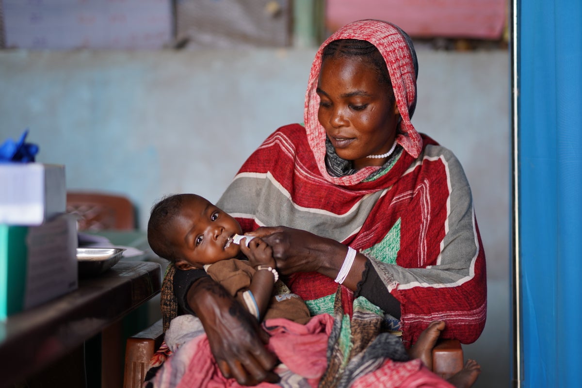 A woman feeds her seven-month-old daughter with a nutrition supplement at a UNICEF-supported nutrition centre in Sudan.