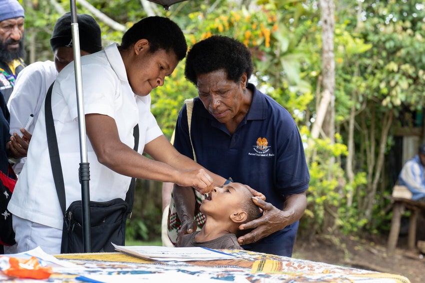 A child receives the polio vaccine from a health worker in Papua New Guinea during round one of the UNICEF-supported polio campaign.   