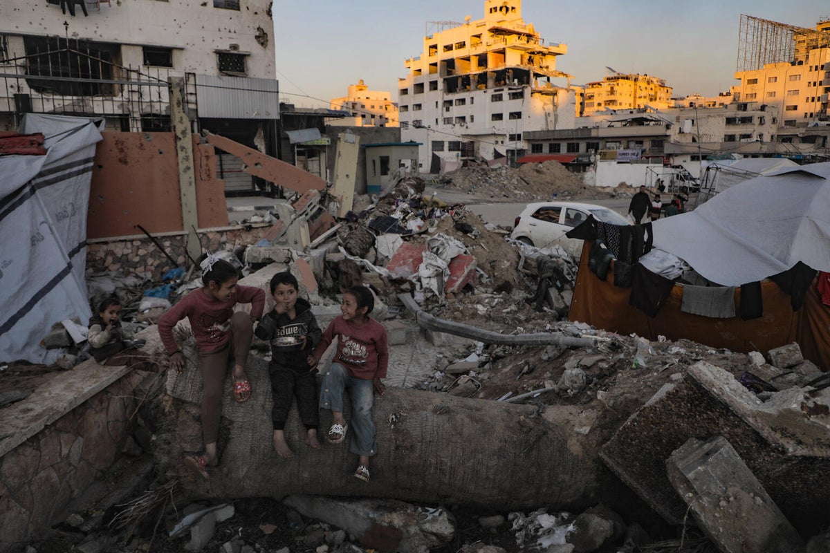 Nine-year-old Noor sits with her three siblings outside their temporary shelter.