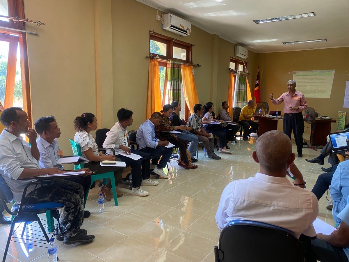 A room full of adults attending a workshop for social welfare in Timor-Leste.