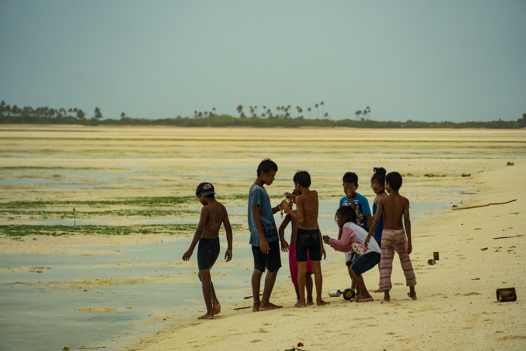 Children playing near the rising pacific ocean's edge