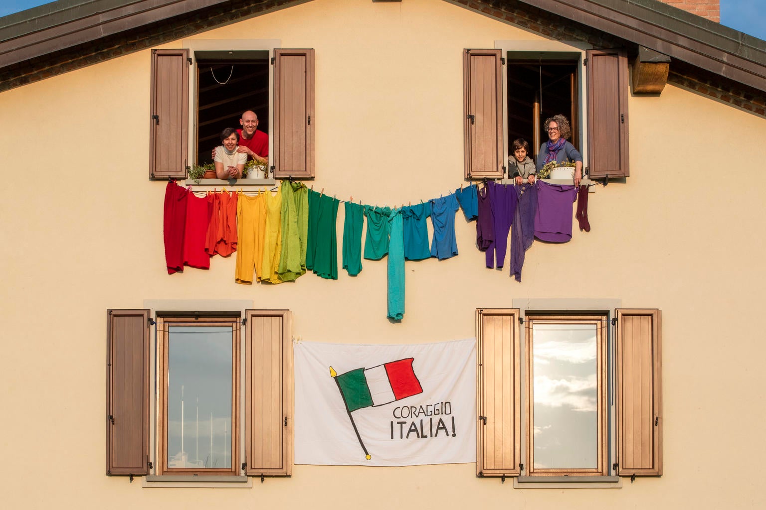 Cristiana made a rainbow out of clothes hung outside her house, involving her children and her next door neighbours in Bergamo, Italy on 20 March 2020. The message on the flag says: "Courage Italy".