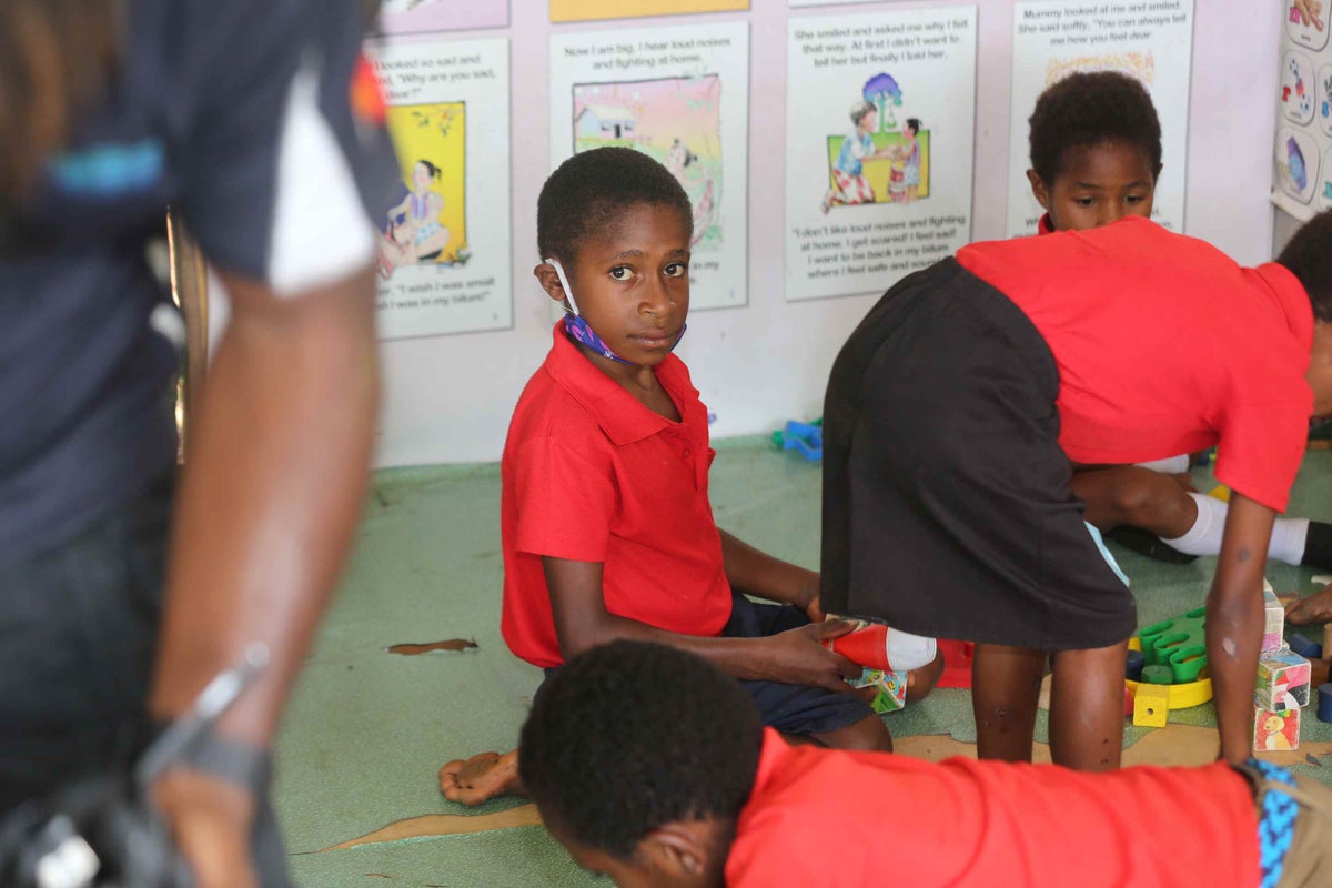 Child sitting on the floor in classroom playing