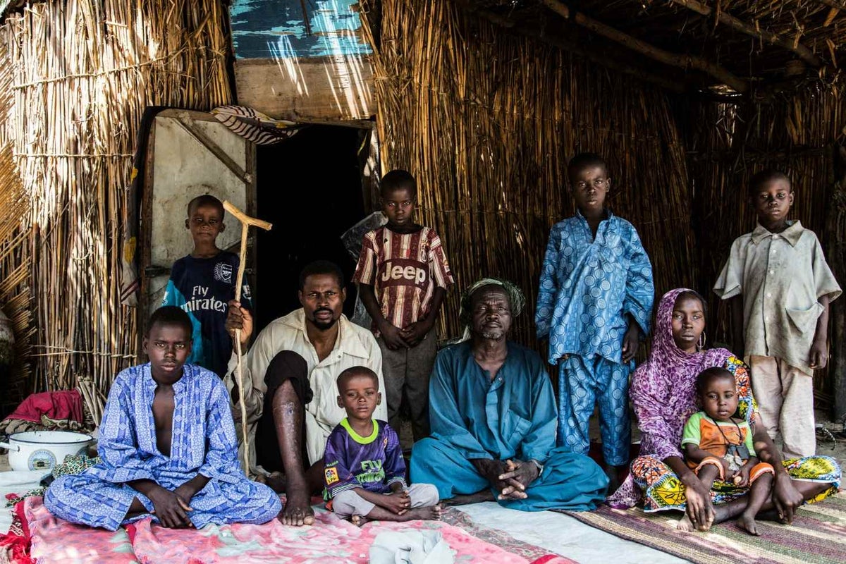 A family with guests, sitting in a hut