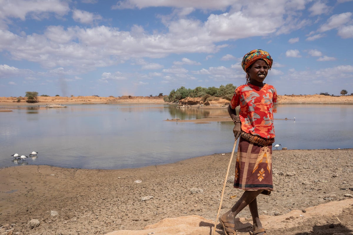 10-year-old Bukhari is at the water site helping his mother collect and transport water.