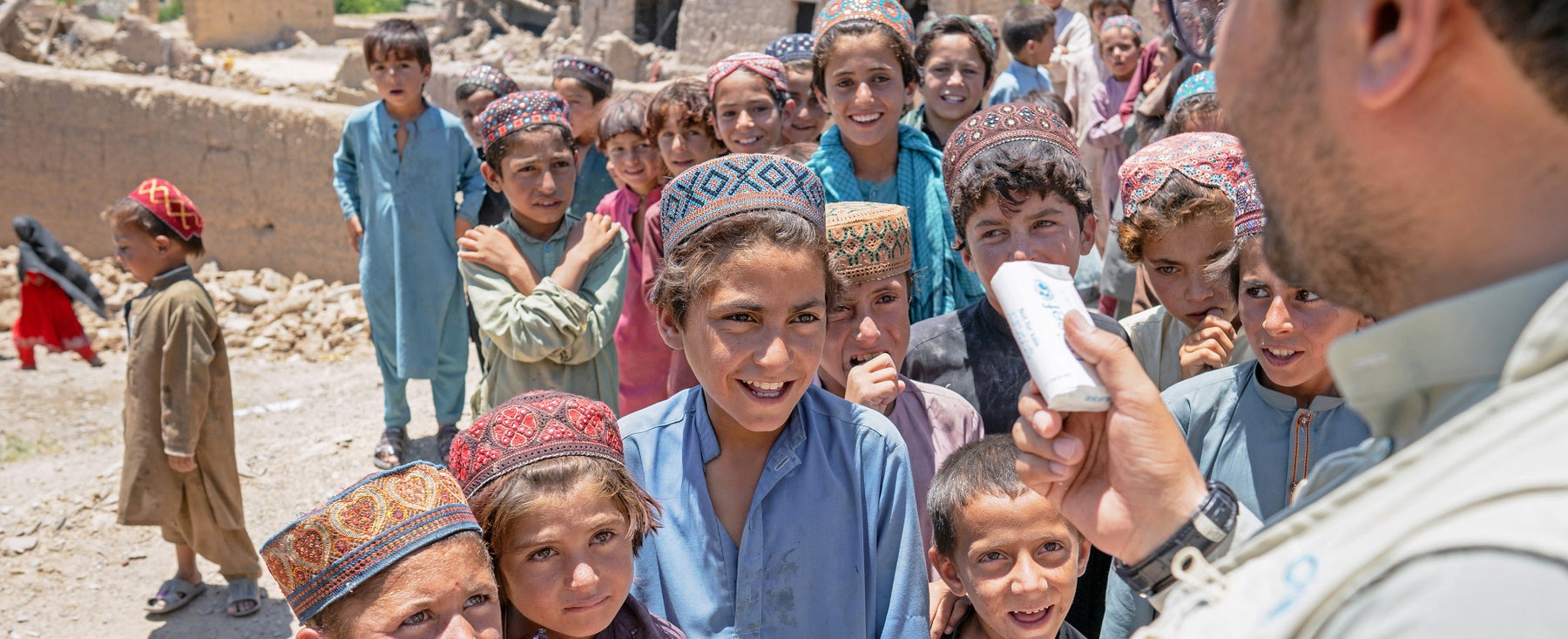 Children waiting for hygiene products from UNICEF WASH officer