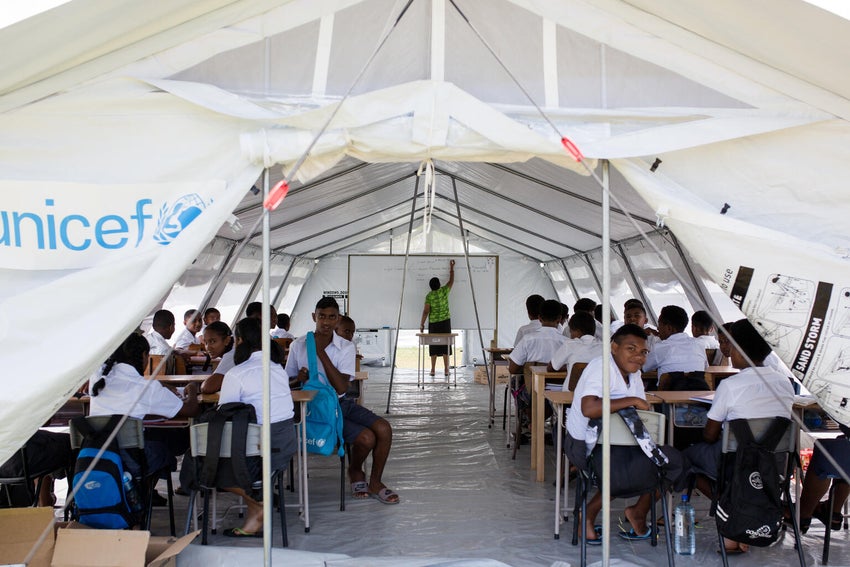 In Fiji, students attend school in a temporary shelter after their school was damaged from a natural disaster.  