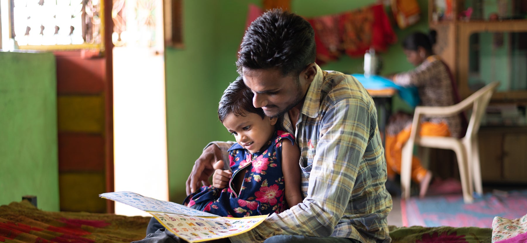 Fathers sits with daughter to read