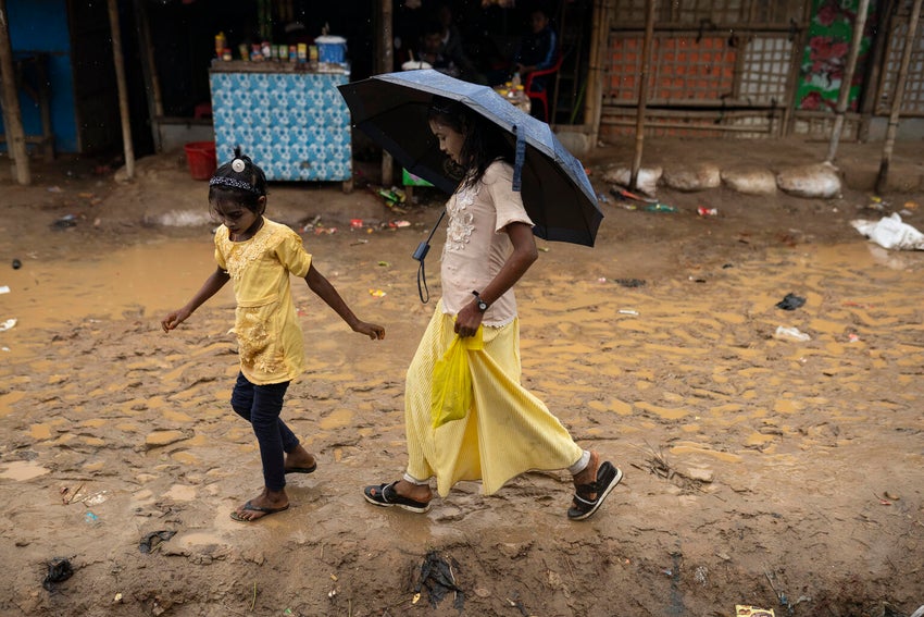 Children shelter from the rain at Cox’s Bazar during monsoonal rains.  