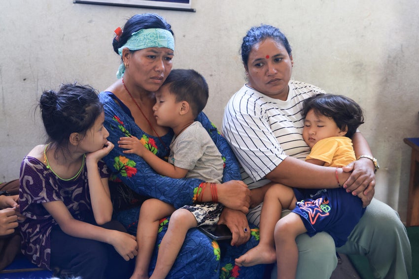 UNICEF staff meet with children and families sheltering in a school in Nuwakot District, Nepal, after floods destroyed their homes and surrounding areas.