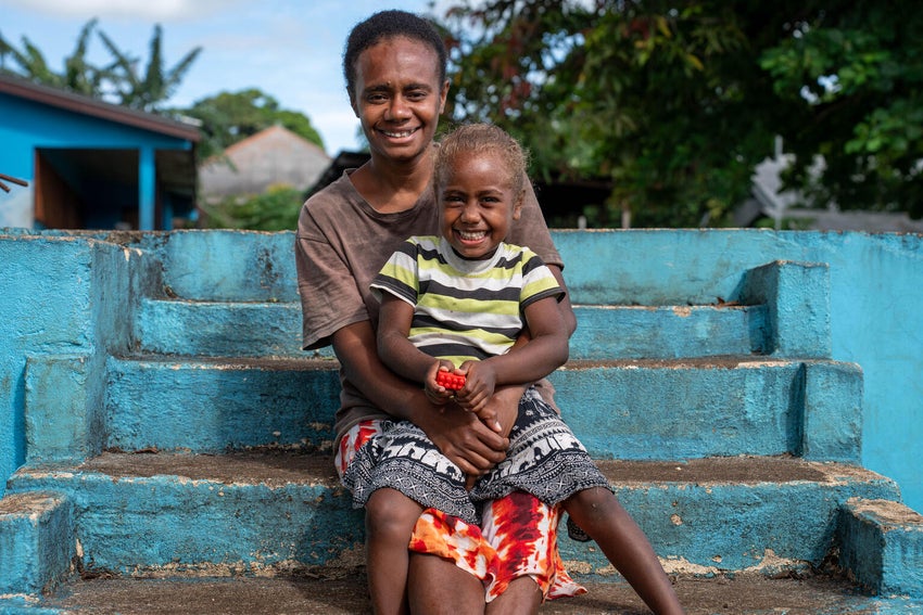 In Vanuatu, a mother and her daughter sit outside a UNICEF-supported health centre.