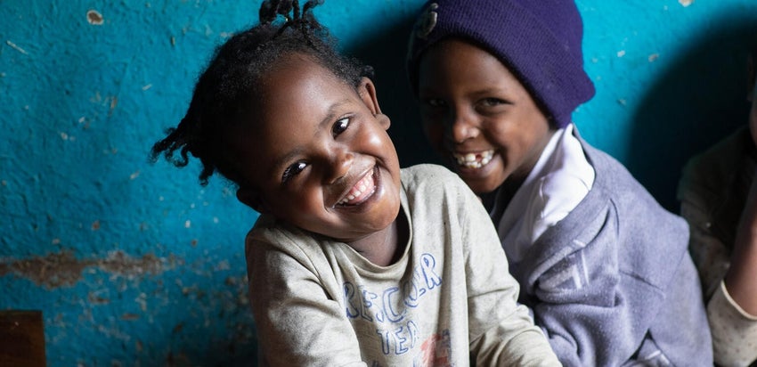Two young children smile at the camera at an early education centre in Ethiopia.
