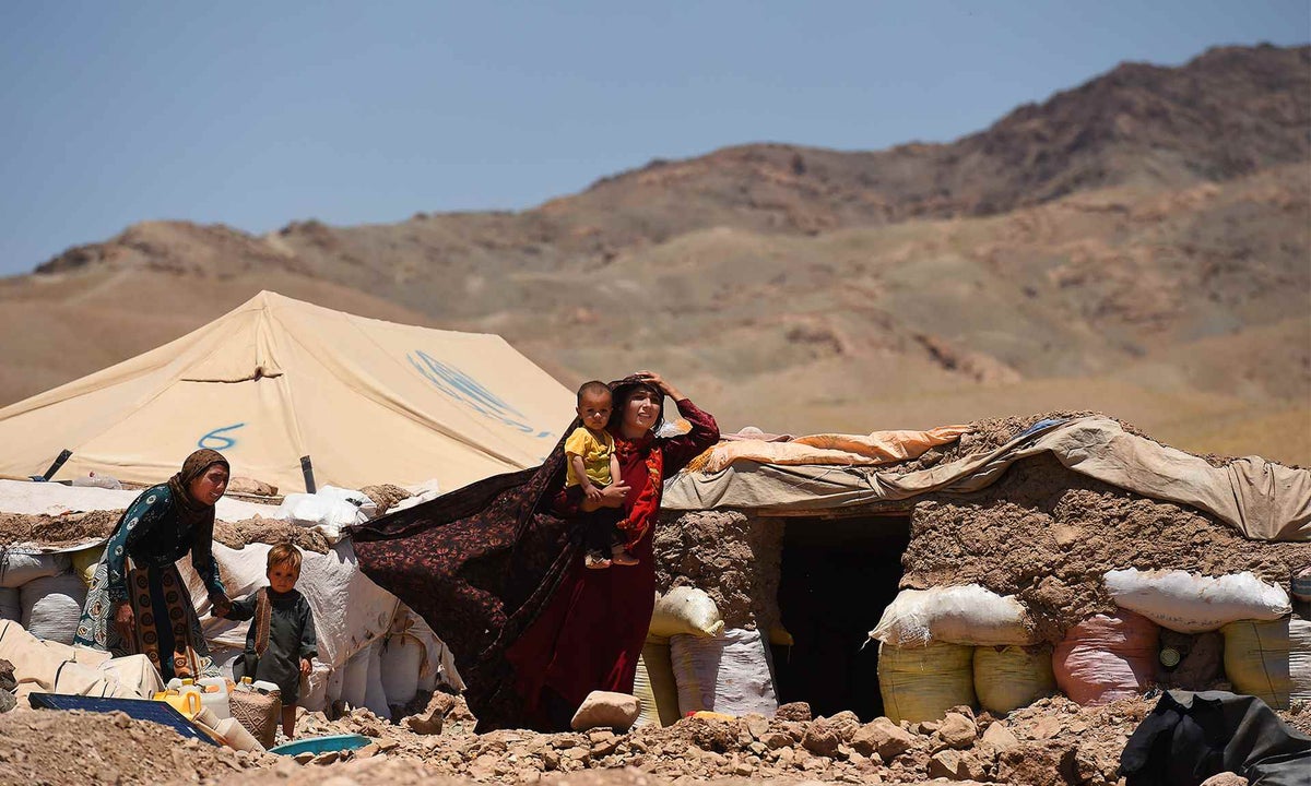 Family standing out the front of a makeshift tent.