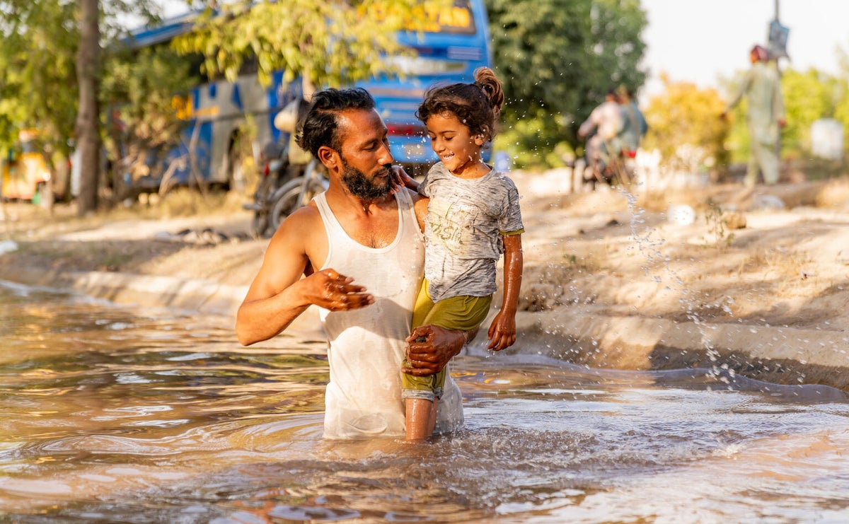 Muhammed shares a refreshing moment with his four-year-old daughter, Ayesha, as they splash in the canal in 47 °C heat. 