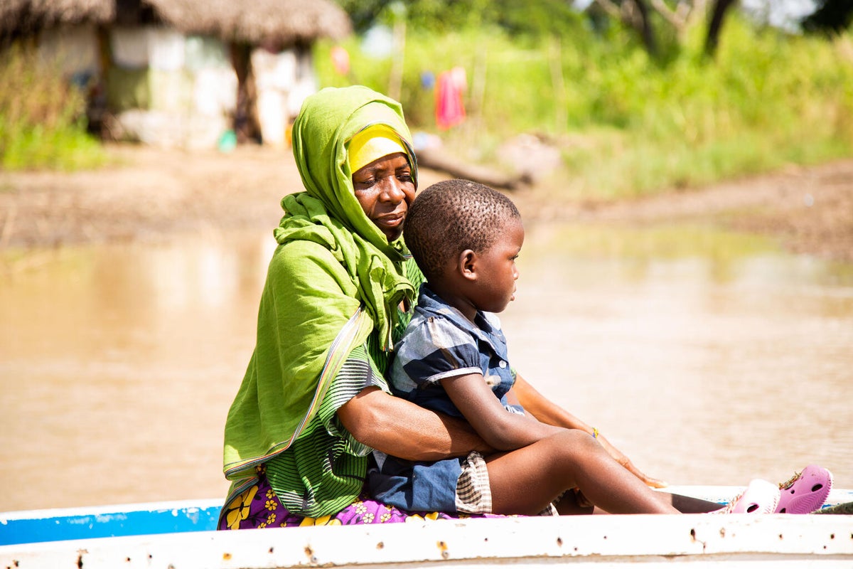 A grandmother holds her young granddaughter on a boat in a flooded waterway in Tanzania. 
