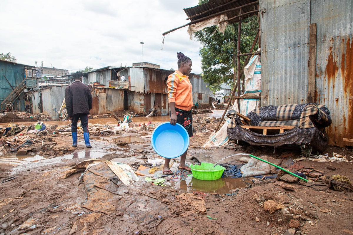 A woman fetches water from a destroyed water pipe in an informal settlement in Nairobi, Kenya.