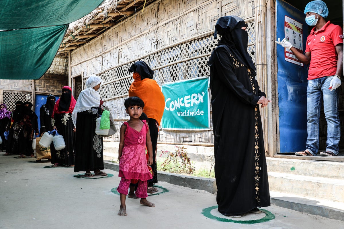 A group of people is waiting for their turn outside a medical centre.