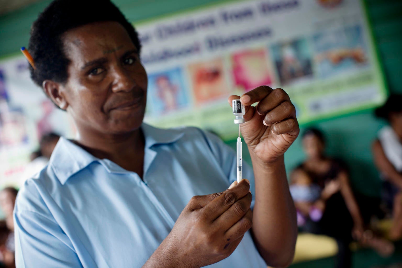 A man is drawing a vile to prepare a vaccine.