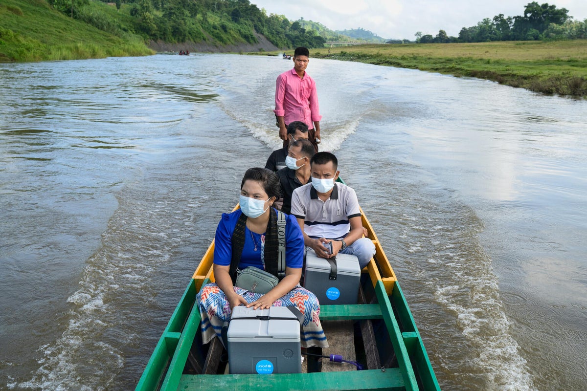 Volunteer health workers travelling to remote rural communities by boat to deliver vaccination sessions for routine childhood immunizations in Bangladesh.