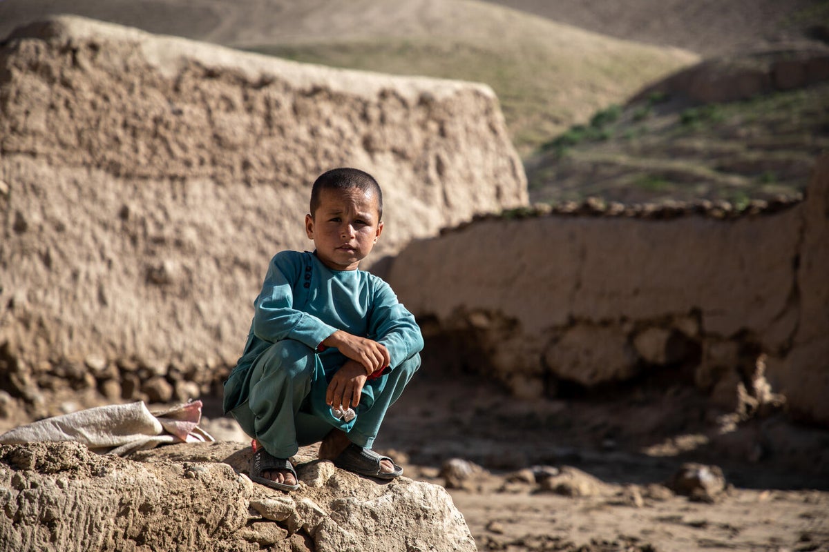 Mohammad, eight years old, sits where his home used to be before it was destroyed in flash floods in northern Afghanistan.