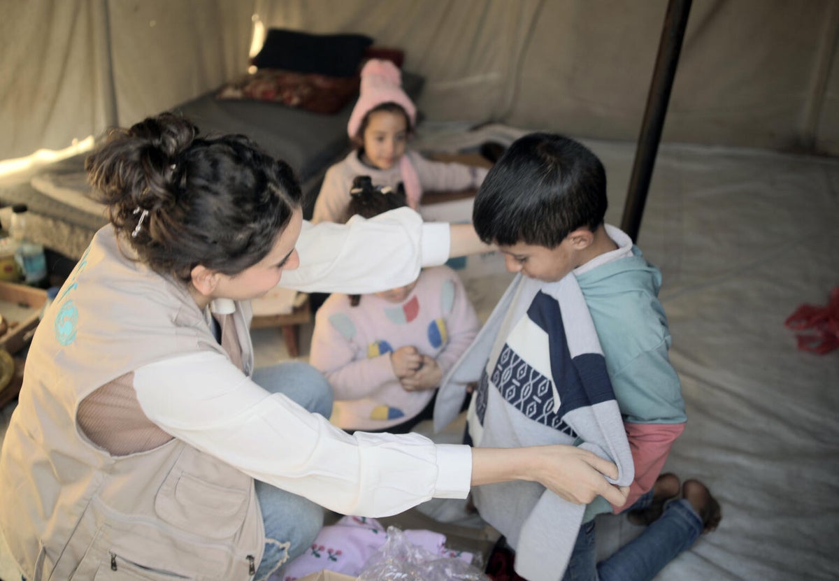 A UNICEF team member distributes winter clothes.