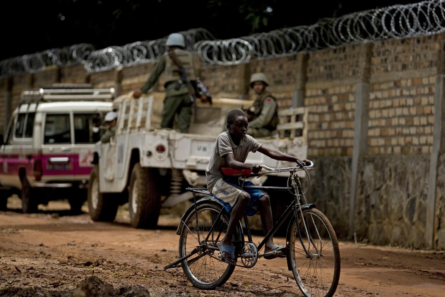 A boy rides a bicycle past a United Nations compound in the remote north-eastern town of Dungu in Oriental Province.