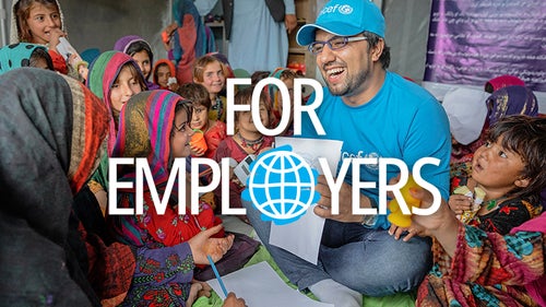 A UNICEF worker teaching a class of students.
