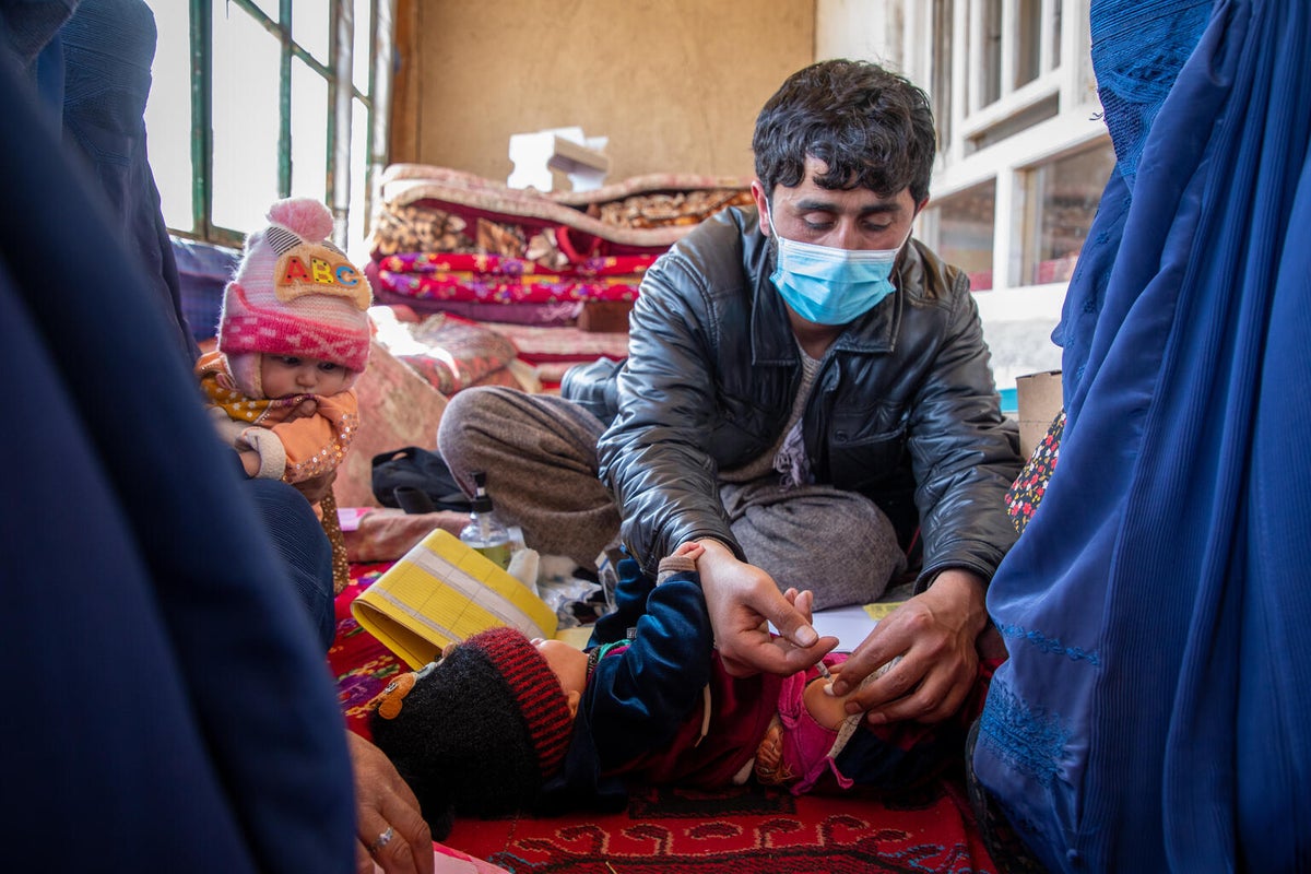 A man vaccinating a baby in rural Afghanistan. 
