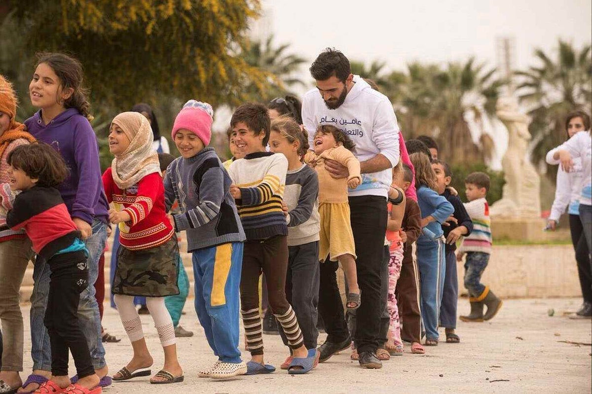 Bilal walking with children in the playground