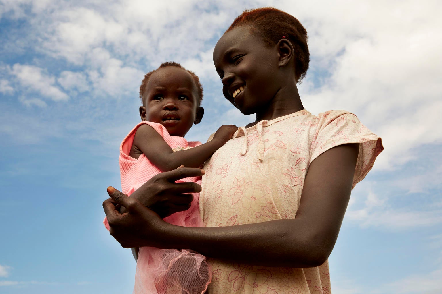 A young woman holds a toddler.